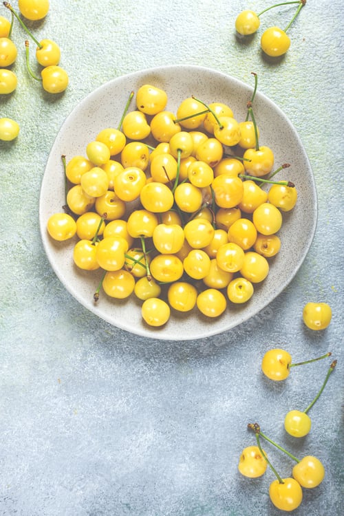 Preview: yellow cherry, cherry berry, scattered on a plate, top view, no people,