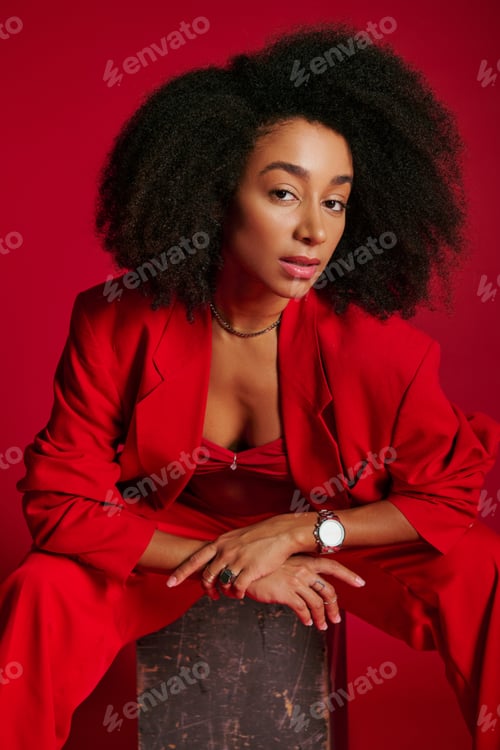 Preview: appealing sexy african american woman in red attire sitting and looking at camera, fashion concept