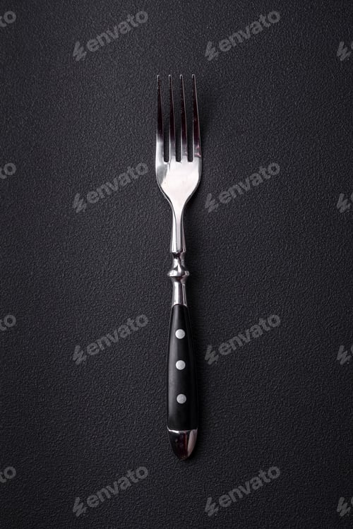 Preview: Metal kitchen fork on a dark textured concrete background