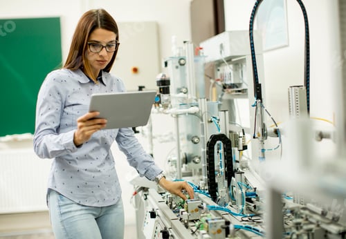 Preview: Young female student of robotics stands in a lab