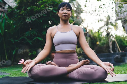 Preview: Girl practicing yoga on fitness mat in yard