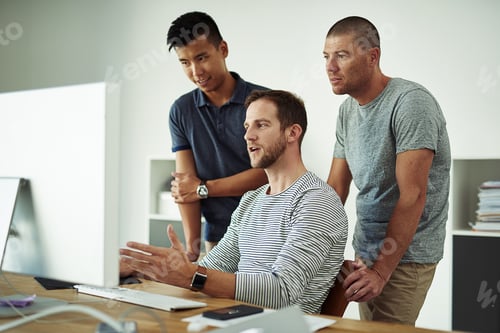 Preview: Cropped shot of three designers working together on a project in an office