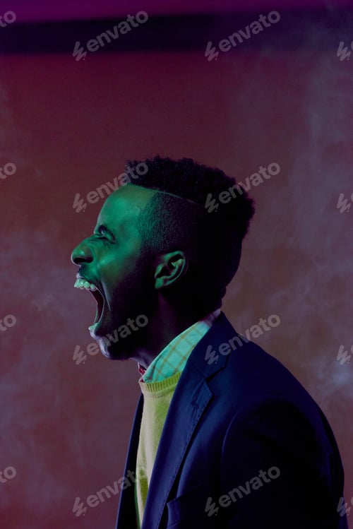 Preview: Studio Portrait of Young Black Man Yelling in Dark