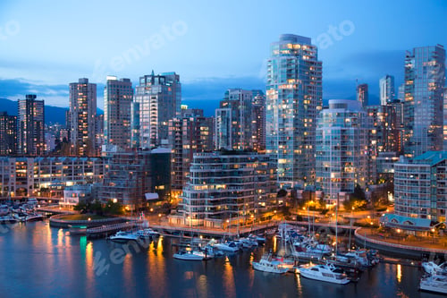 Preview: Illuminated cityscape with skyscrapers, river and yachts moored in marina in the evening.