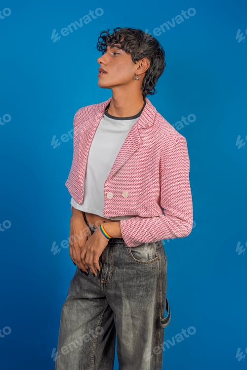 Preview: Young latin man wearing pink jacket and rainbow bracelet posing on blue background