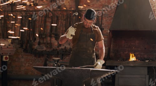 Preview: Shot of a metal worker hitting a hot metal rod with a hammer in a welding workshop