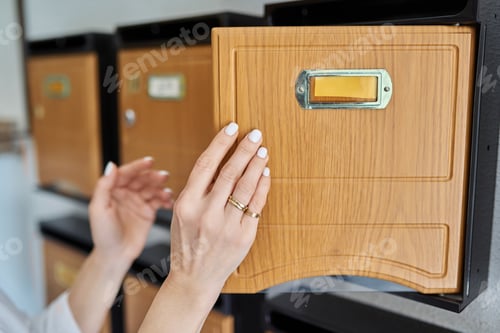 Preview: Woman checking mailboxes inside an apartment building