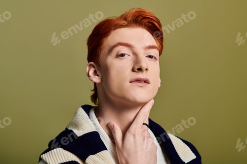 Preview: Young man with striking red hair showcases emotion and charm against a muted background