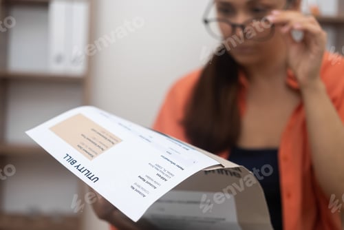Preview: woman over utility bills, mentally crunching numbers mounting electricity, water, and internet bills