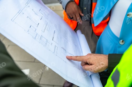 Preview: Construction team reviewing blueprint and architectural plans