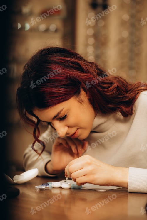 Preview: Woman holding a container with contact lenses for vision correction