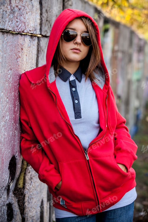 Preview: Teen girl in sunglasses near graffiti wall.