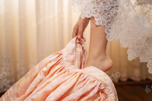 Preview: Bride getting dressed putting on peach colored wedding dress