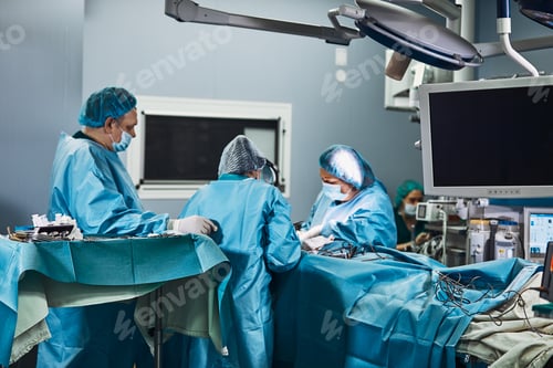 Preview: Surgical team operating on patient in theater in hospital