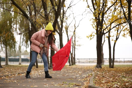 Preview: Woman with red umbrella caught in gust of wind outdoors