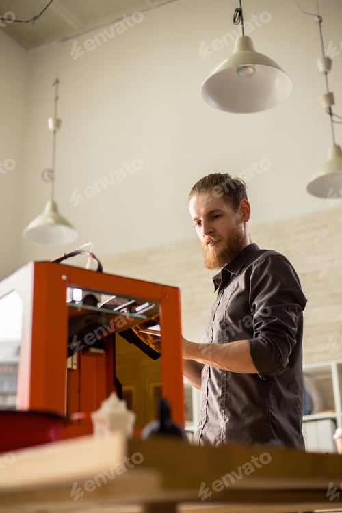 Man Uses 3D Printer at Workplace