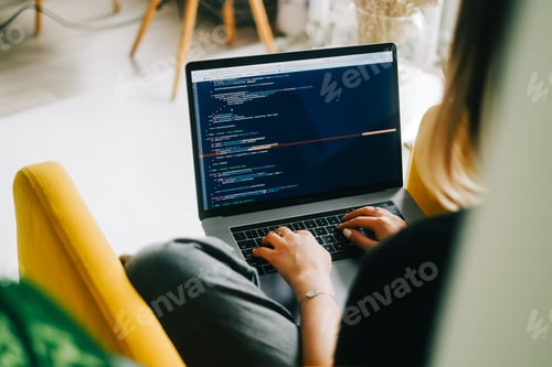 Preview: Young woman mobile developer writes program code on a computer, programmer work.