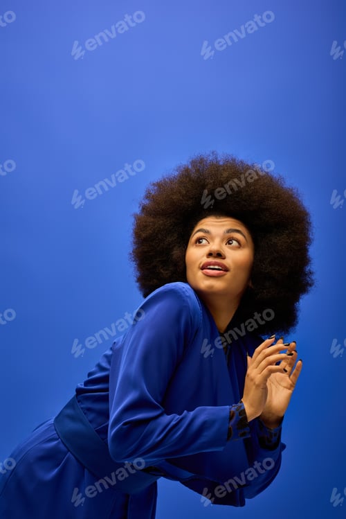 Preview: Afro Chic: Stylish Woman Posing Against Vibrant Blue
