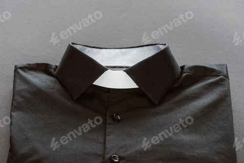 Preview: close-up shot of clerical shirt with white collar on grey surface