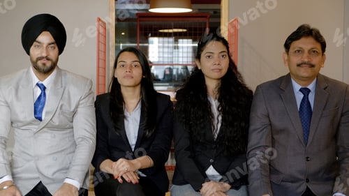 Preview: Portrait of four colleagues from India in formal wear smiling for the camera