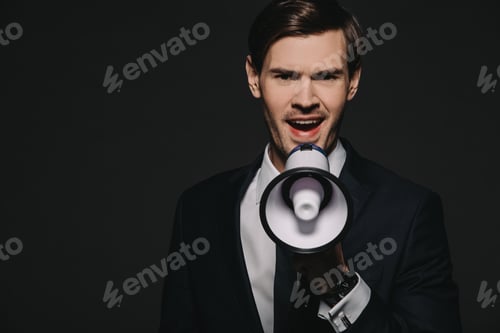 Preview: handsmome man in suit screaming in megaphone isolated on black