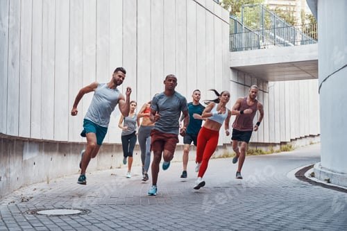 Preview: Full Length Of Young People In Sports Clothing Jogging While Exercising Outdoors