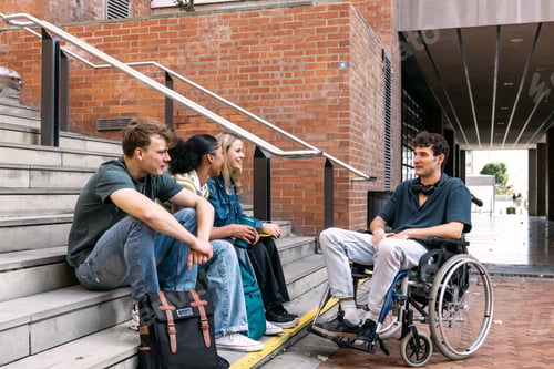 Preview: Diverse students sitting on stairs discussing on campus