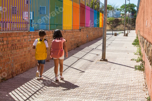 Preview: Children walking to school on sunny street with backpacks