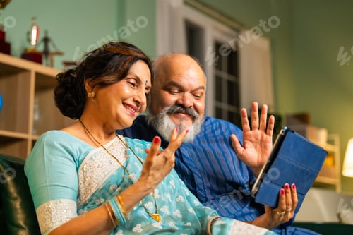Senior Couple Video Conferencing at Home on Tablet