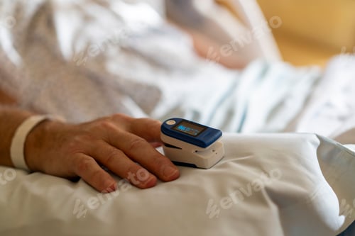 Preview: Close-up of patient's hand with pulse oximeter monitoring oxygen saturation in hospital