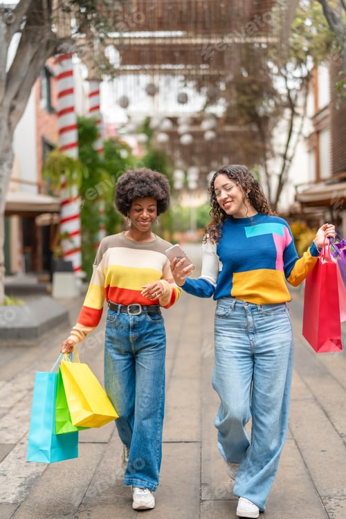 Preview: Young women walking with their shopping bags and making a video
