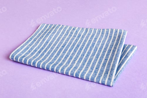 Preview: top view with blue kitchen napkin isolated on table background. Folded cloth