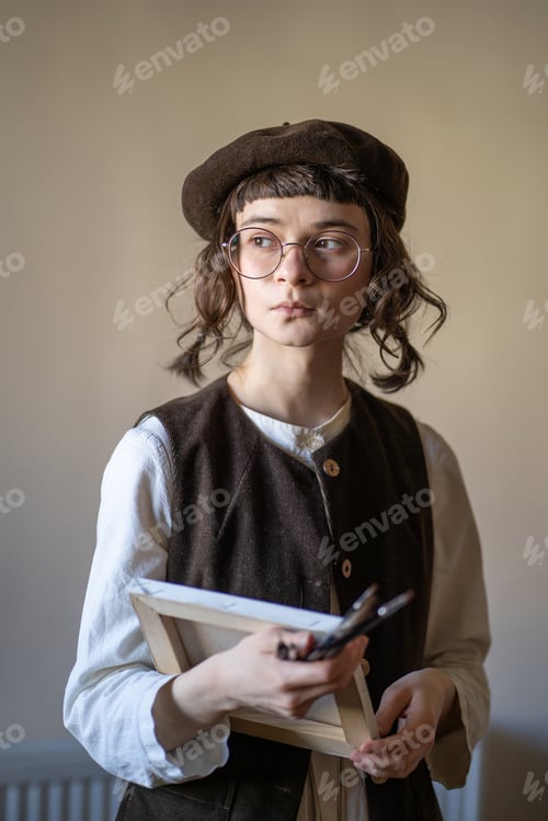 Preview: Talented freelance artist holding canvas, paint brushes, looking at window, preparing for work