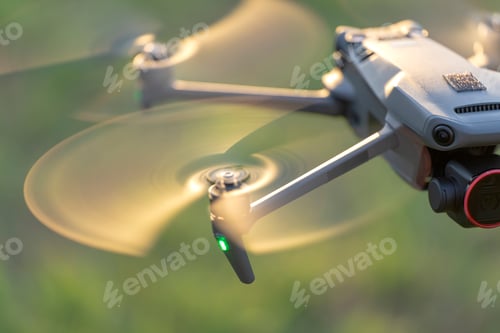 Preview: Drone quadcopter with digital camera and fast rotating propellers flying taking video and pictures