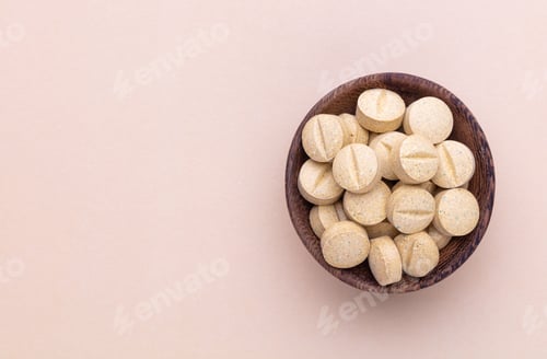 Preview: Alternative medicine tablets on a wooden spoon.