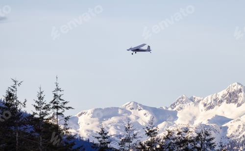 Preview: Small Airplane flying around Canadian Mountain Landscape.