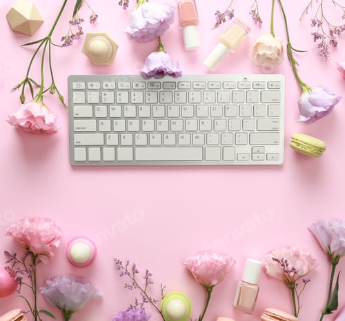Preview: Flat lay composition with keyboard and flowers on pink background. Beauty blogger's workplace