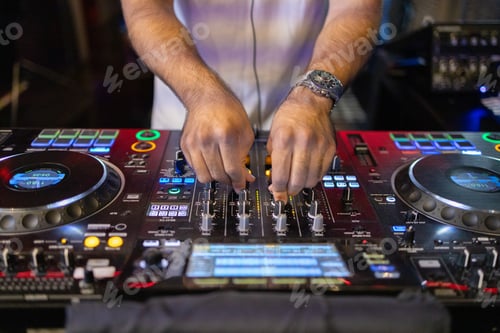 Preview: DJ's Hands Adjusting Music Mixer at Event