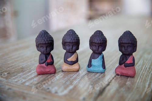 Preview: Four small colorful Buddha for kids on wooden background