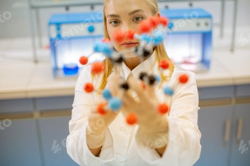 Preview: Female chemist hold molecular model in the lab