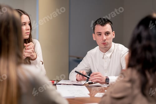 Preview: colleagues at a large table in the company discuss a concept for a new project during a brainstorm