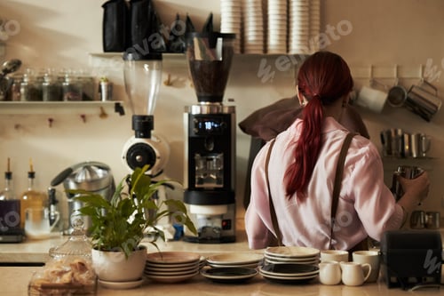 Preview: Young Adult Caucasian Woman Preparing Coffee Drink Behind Cafe Counter