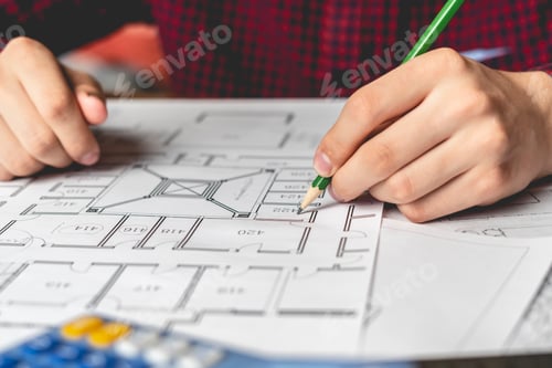 Preview: engineer sketching building project on a blueprint with a pencil b
