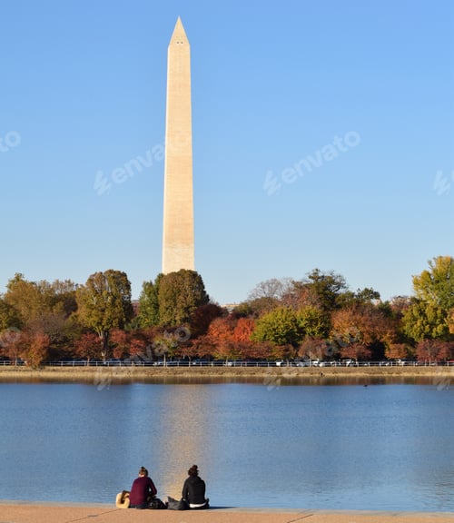 Preview: Friends sitting next to the blue water at the park with the Washington Monument in the distance and