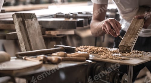 Preview: male carpenter working with a wood product, hand tools