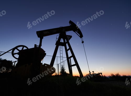Preview: Oil field with petroleum pump jack under beautiful night sky.