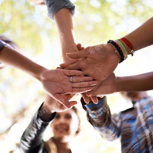 Preview: Friends that stick together. A group of friends standing in a huddle with their hands piled.