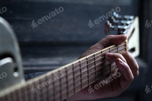 Preview: fingers on guitar dark background