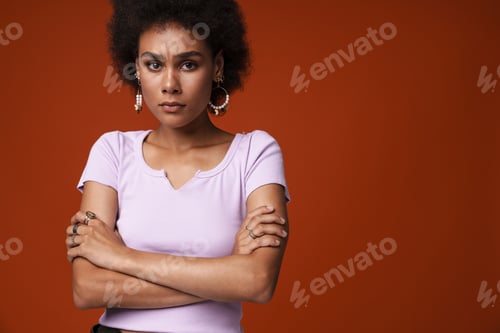 Preview: Young black woman wearing earrings frowning and looking at camera