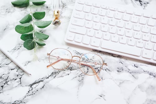 Preview: Conceptual White marble Office Desk with keyboard and eyeglasses
